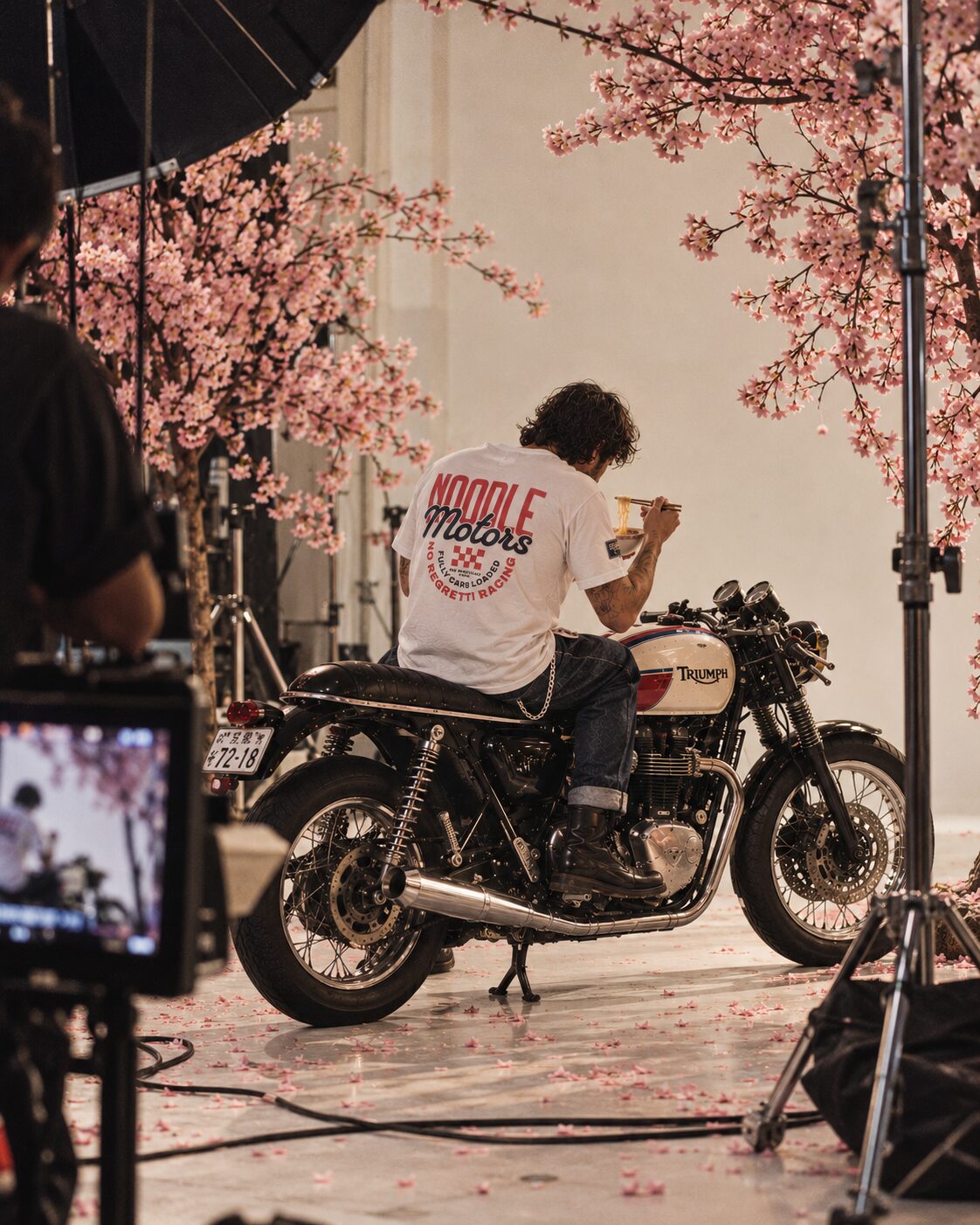 Noodle Motors tee on a motorbike under cherry blossoms